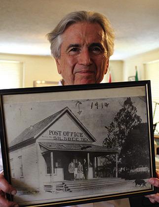 Jimmy McKim, chairman of the Hardin County Historical Commission, holds this 1914 photo of the Silsbee Post Office. He is pointing to a pig in the lower right hand corner of the photo. Notice that boards were placed under the porch of the post office to keep pigs out. This photo, taken over 108 years ago, is on a shelf on the second floor of the museum.