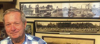 Museum of Hardin County volunteer David Martin stands in front of some panoramic photos taken many years ago in Hardin County.