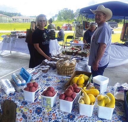 Donya McLaurin, left, president of the Kountze Chamber of Commerce, visits with David Rabala, who brought fruits and vegetables from Winnie to sell at the farmers market last Saturday in Kountze.The next farmers market will be from 8 a.m. to 11 a.m. June 3 at George Washington Carver Park in Kountze.