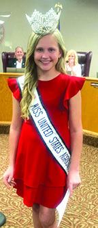 Brooke Brinkley, a fifth grader at Lumberton Elementary School, is wearing the crown and sash as Miss United States Agriculture. She made an appearance last Thursday night at the Lumberton school board meeting and passed out gifts to board members. Photo By Dan Eakin