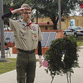 A member of Boy Scout Troop 88 salutes after having placed a wreath in honor of veterans and those who serve in a branch of the armed forces.A total of eight boy scouts each placed a wreath in honor of a branch of service.