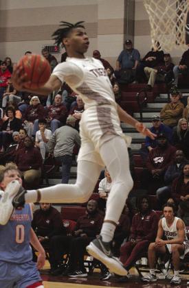 Jarad Harris (1) goes into the wind-up for a dunk shot during the Tigers win over Lumberton. For most players this is a big deal but Harris does it three or four times each game.