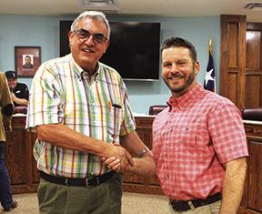 Danny Reneau, left, who was elected mayor in the May 6 city council election, shakes hands with Kevin Garner, outgoing mayor, who chose not to seek re-election.