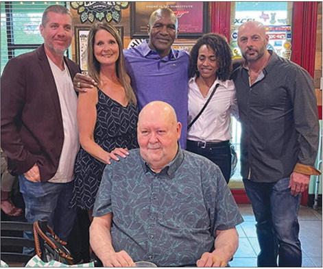 Four time heavyweight boxing champion Evander Holyfield (middle) stands with Craig Stilley (right) and Dan Stilley (bottom) and friends as they celebrate Stilley Enterprise in Orange.