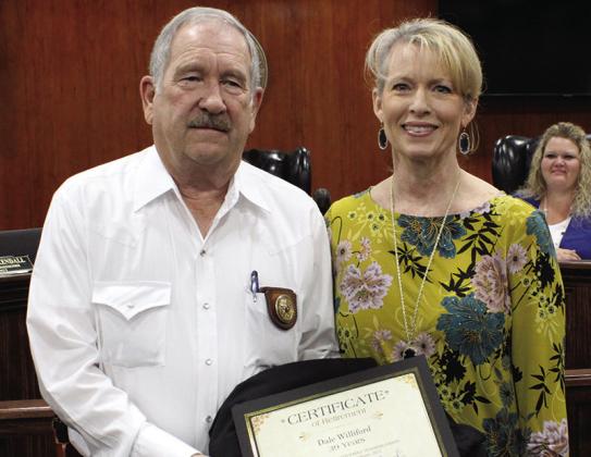 Dale Williford, left, is presented with a Certificate of Appreciation from Hardin County District Attorney Rebecca Walton at the Hardin County Commissioners Court meeting Tuesday. The commissioners also unanimously passed a resolution honoring Williford for more than 40 years of service in law enforcement in Hardin County.