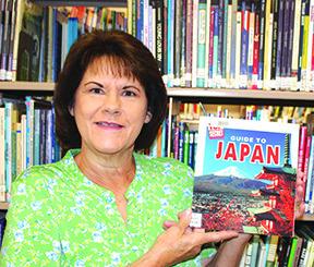 Cathy Johnson, Silsbee Public Library director, holds one of the books on Japan that will be used to teach kids about that country on June 13 &amp; 15. Dan Eakin Photo