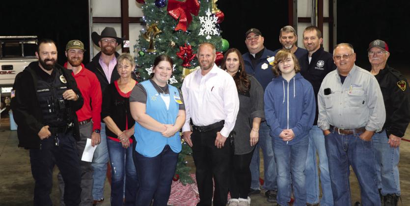 The workers in the Sharyn the Blessing program gather in front of the Christmas tree in the Central Fire Hall. The group includes Officer Johnny Crawford, fireman Bailey Holt, Fireman Haiden Hughes, Mrs. Plaunty, Walmart employee Brittany Tatum, Chief Shawn Blackwell, Jamie Plaunty, Walmart manager Daniel Tucker, Luke McClammey, Assistant Fire Chief Mike Morrison, Vincent McClammy, Donnie Cain and Fireman Lenox Hawthorne. Photo by Danny Reneau