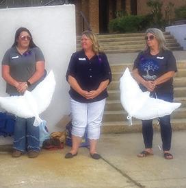Two CASA volunteers hold dove shaped biodegradable balloons which were released in memory of two children who died as a result of child abuse in Jasper County and Tyler County last year.