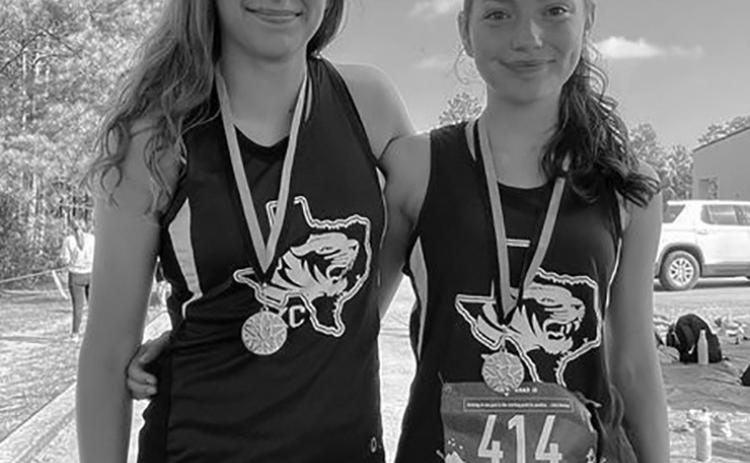 Kristina Eyre and Claire Uribe with their medals from the Woodville cross country meet. Photo Courtesy of Chelsey Holmes Garrett.