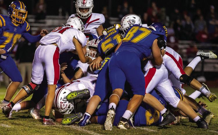 Host of Rebels pile on the Bulldogs ball carrier. Photo courtesy of Julie Isbell.