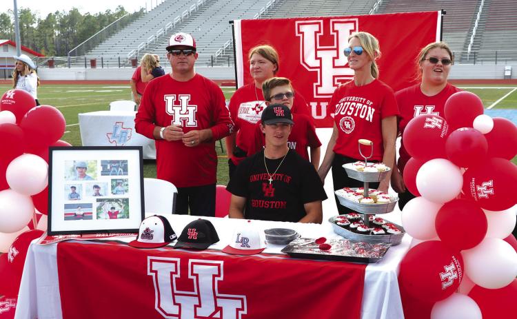 Tine Hampshire signed a letter of intent to play baseball at the University of Houston. He has played the infield and batted near .400 for the Raiders. He hopes to also see duty on the Cougars pitching staff. His family are proud to be pictured with him. Photo by Danny Reneau