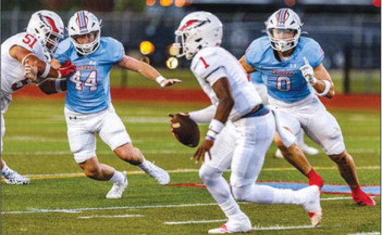 Julius White (44) and Brock Jackson (0) put the pressure on the Eagles quarterback in Friday night’s game.The Eagles won 35-20. Brent Guidry photo