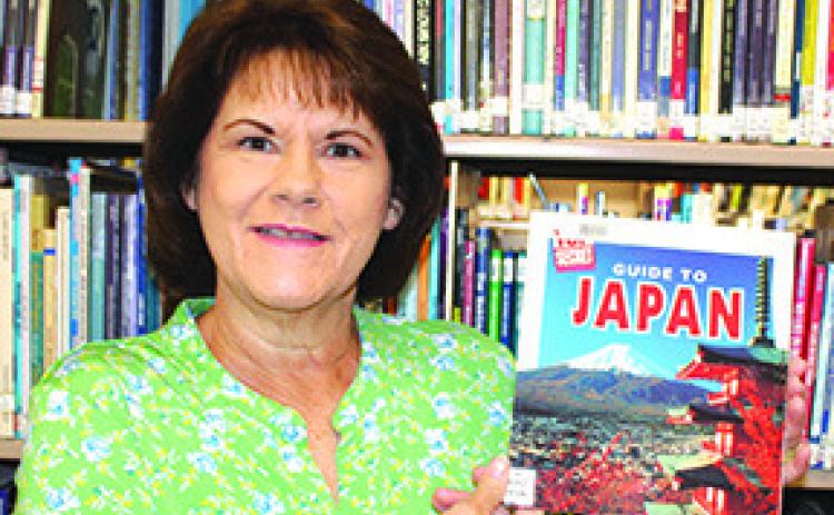 Cathy Johnson, Silsbee Public Library director, holds one of the books on Japan that will be used to teach kids about that country on June 13 &amp; 15. Dan Eakin Photo