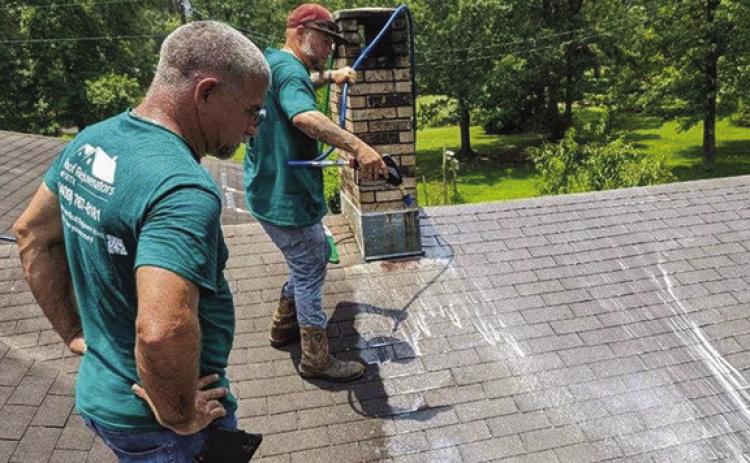 Michael Smith and Chuck Guidroz spray a roof rejuvenation product onto a roof.The roof rejuvenation process rehydrates the shingles,adds to the flexibility, reactivates the tar and rebinds the gravel to the shingles, hence extending life to the roof. Roof rejuvenation is often much less expensive than roof repairs or roof replacement. Courtesy photo